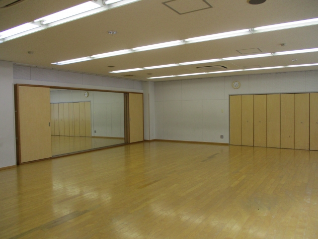一面鏡張り、フローリング床の多目的室を写した写真