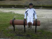 十字懸垂ベンチで運動をしている白いジャージを着た男性の写真