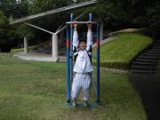 懸垂平行棒で運動をしている白いジャージを着た男性の写真