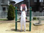 背伸ばしステーションで運動をしている白いジャージを着た男性の写真