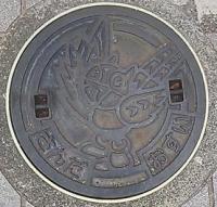 マスコットのキッピーが刻印されている大きな公共マスの蓋の写真
