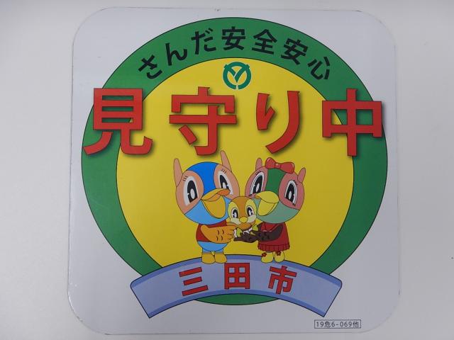 「さんだ安全安心見守り中三田市」と書かれ鳥のキャラクターが描かれたステッカーの写真