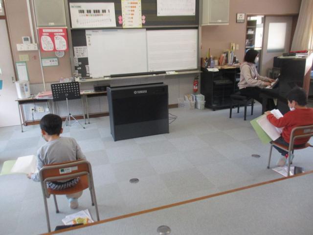 ピアノの伴奏に合わせて合唱をする児童たちの写真