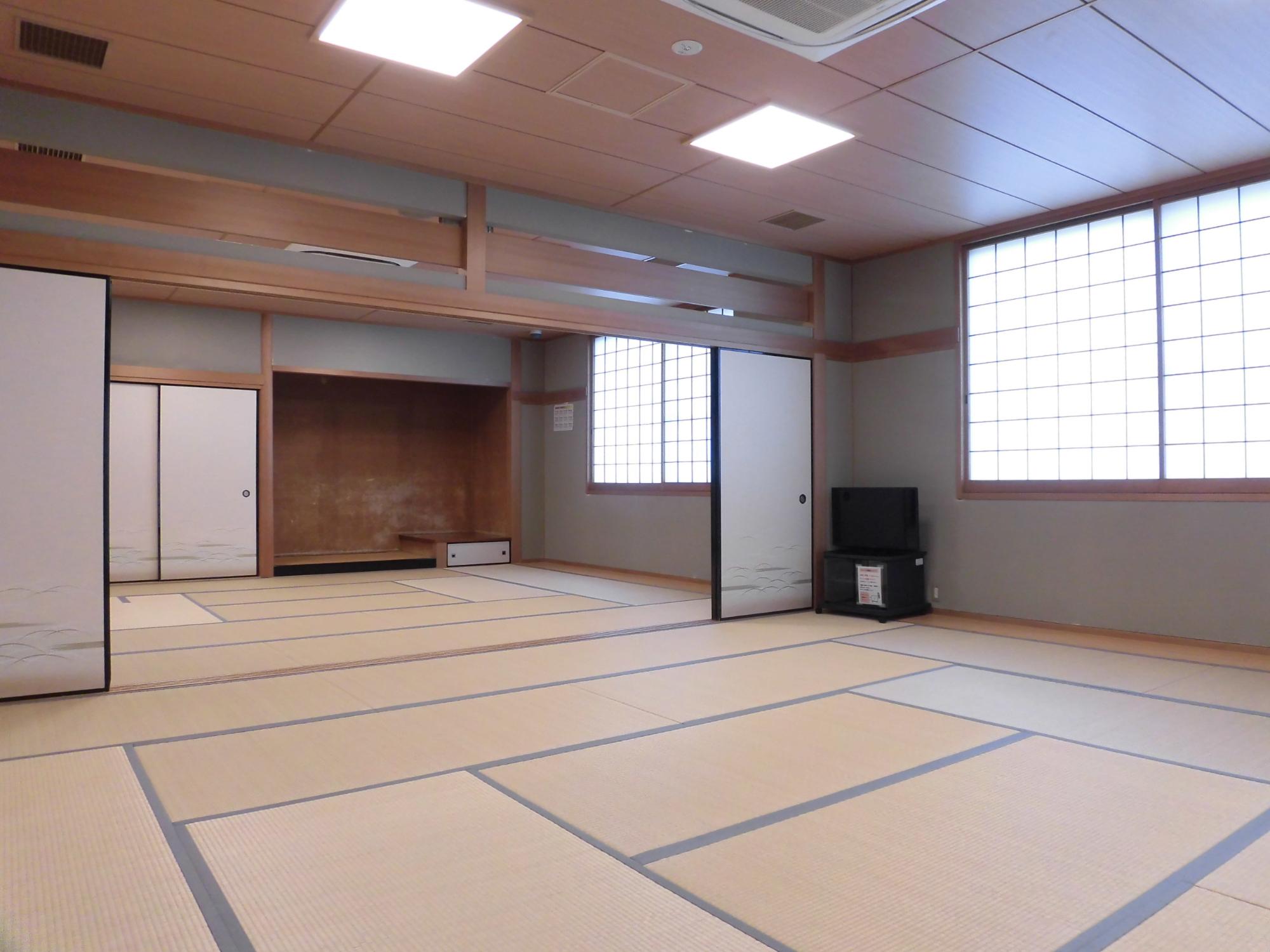 襖で仕切られた奥の部屋に床の間、手前の部屋にブラウン管テレビがある和室(全室)を写した写真