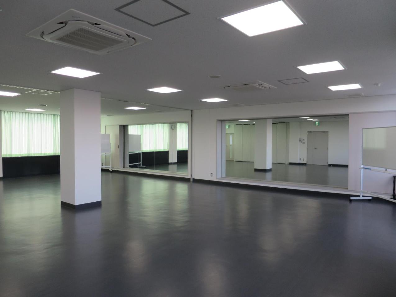 正面に鏡を有した多目的室1Aと1Bの部屋の仕切りパネルを収納した全室を写した写真