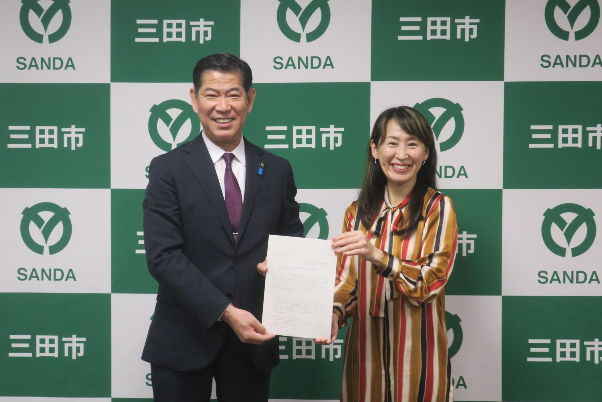 清水委員長と田村市長が答申書を共同で見せる様子