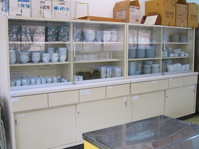 様々な食器が入った食器棚を写した調理実習室の写真