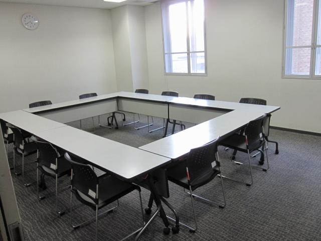 長机を四角く囲み、その周りに椅子を12脚並べた様子を写した会議室2の写真