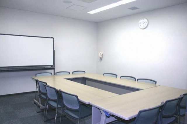 ホワイトボードと、長机を四角く囲みその周りに椅子を並べた様子を写した会議室3の写真