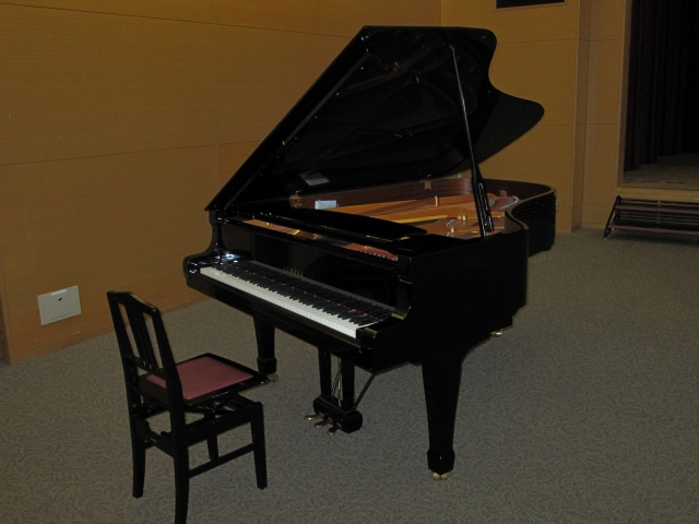 グランドピアノと椅子を写した大集会室の写真