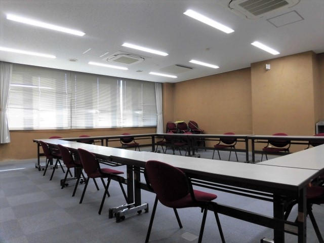 テーブルを四角く囲みその周りに椅子を並べた様子を写した中会議室の写真