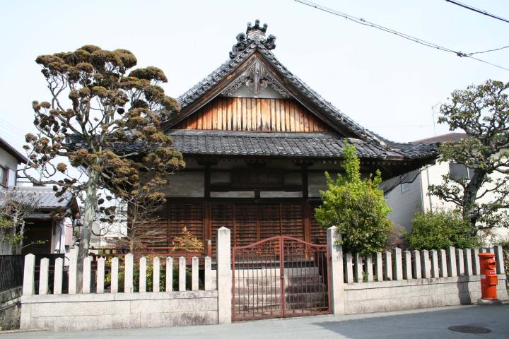 赤色の小さい門の奥に、大きなお堂が建っている写真