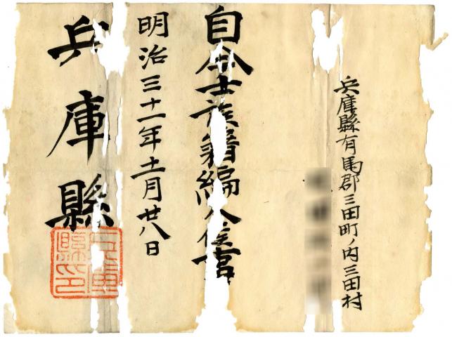 ところどころ破けた紙に、筆で住所や「兵庫県」の文字などが書かれている、士族の辞令の写真