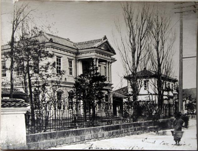 柵と植え込みに囲われた明治40年代の有馬郡役所の写真