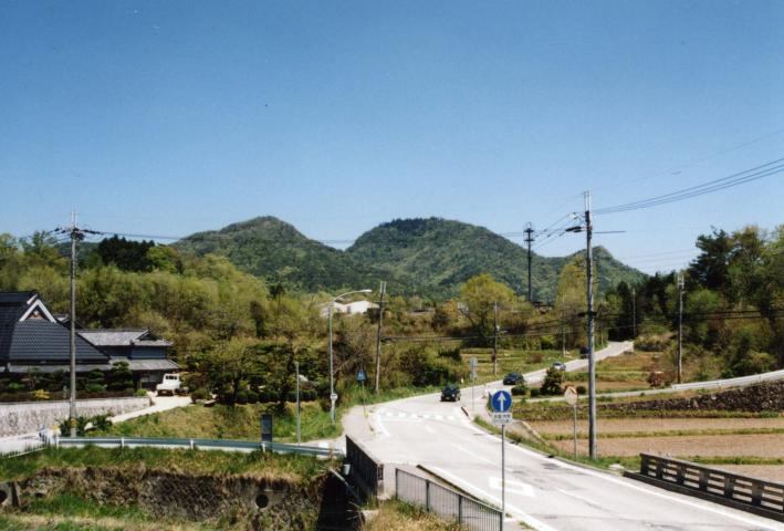 車道の先に、二つの大きな山が見えている写真