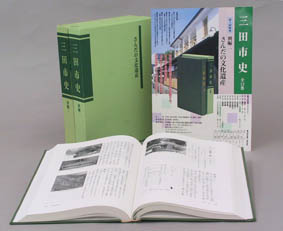 カラーのチラシと背表紙、見開きの状態で置かれた書籍が並ぶ写真