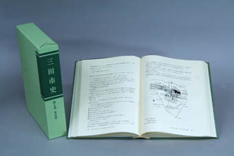 ケースに入った現代資料の背表紙と、開いた状態の書籍が並んで置かれている写真