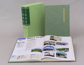 カラーページが見開きになった状態で置かれた「三田市史 別編1 さんだ40年のあゆみ」の見本写真