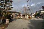 植木と青空と民家の映る上野原三叉路の写真