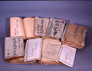 年代物の旧町村文書がテーブルの上に並べて置かれている写真