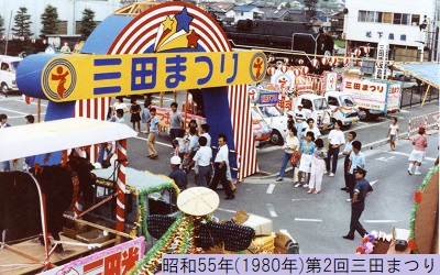 昭和55年におこなわれた第2回三田まつりのおまつり広場の入り口に置かれているロゴマークが描かれたバルーンアーチにを通る人々の写真