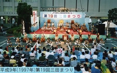 平成9年におこなわれた第19回三田まつりの三田太鼓ステージでの演奏している様子を観客の背中側から撮影した写真