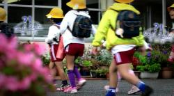 三田市内にある幼稚園に登園するお揃いのえんじ色の半ズボン姿で黄色帽を被りリックを背負った園児たちの写真