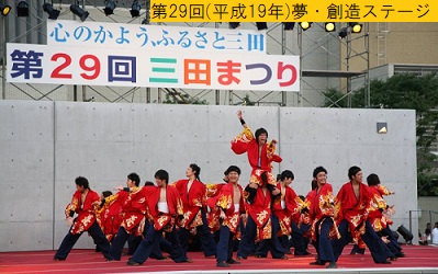 平成19年におこなわれた第29回三田まつりの夢創造ステージでお揃いの赤色の法被姿で踊るよさこいチームの写真