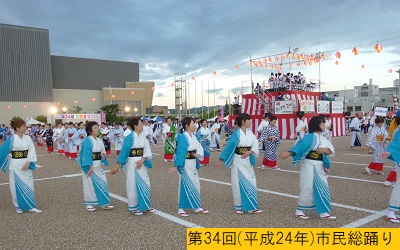 平成24年の第34回三田まつりの野外会場に設置されたやぐらを囲むように浴衣姿で市民総踊りをおこなう人々の写真