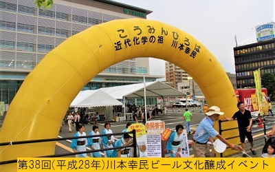 平成28年の第38回三田まつりで入り口に黄色のバルーンアーチが飾られた市役所前風の広場の川本幸民ブースでおこなわれたビール醸成イベントの様子を撮影した写真