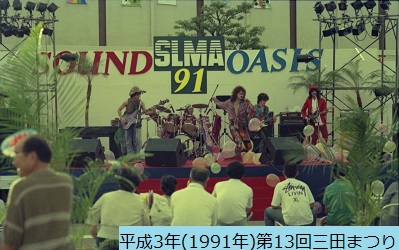 平成3年におこなわれた第13回三田まつりの音楽ステージで演奏するバンドを観客の背中側から撮影した写真