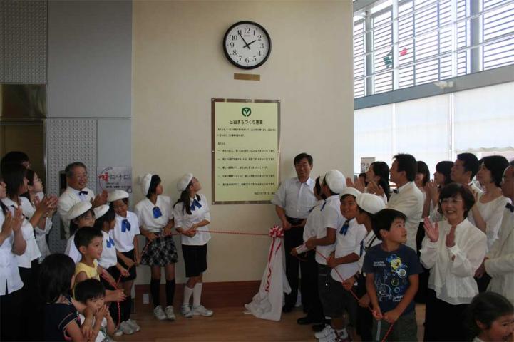 7月5日のさとのねホール1階エントランスにおける、憲章板の除幕式の様子をおさめた写真