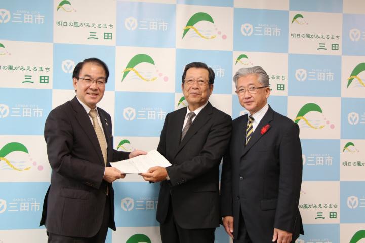 答申書提出に臨んで撮影に応じる、森市長と中瀬氏たちの写真