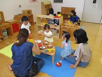 「親子サロン」のスペースで、おままごとをして遊ぶ親子の写真