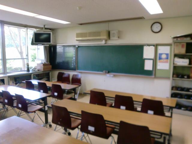 長い机が並んだ黒板のある教室