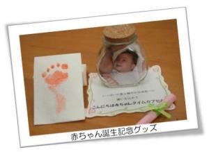 赤い足型、赤ちゃんの写真が入っている瓶、メッセージカードなど赤ちゃん誕生記念グッズが写っている写真