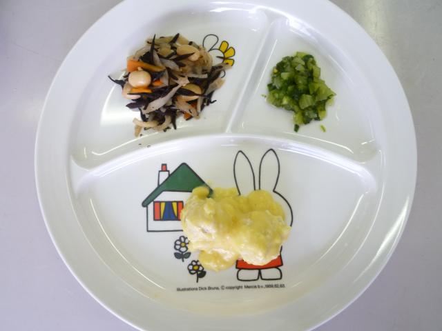かみかみ教室試食用のひじきの煮物と緑色の菜っ葉と白いクリームの離乳食が乗ったワンプレートの写真