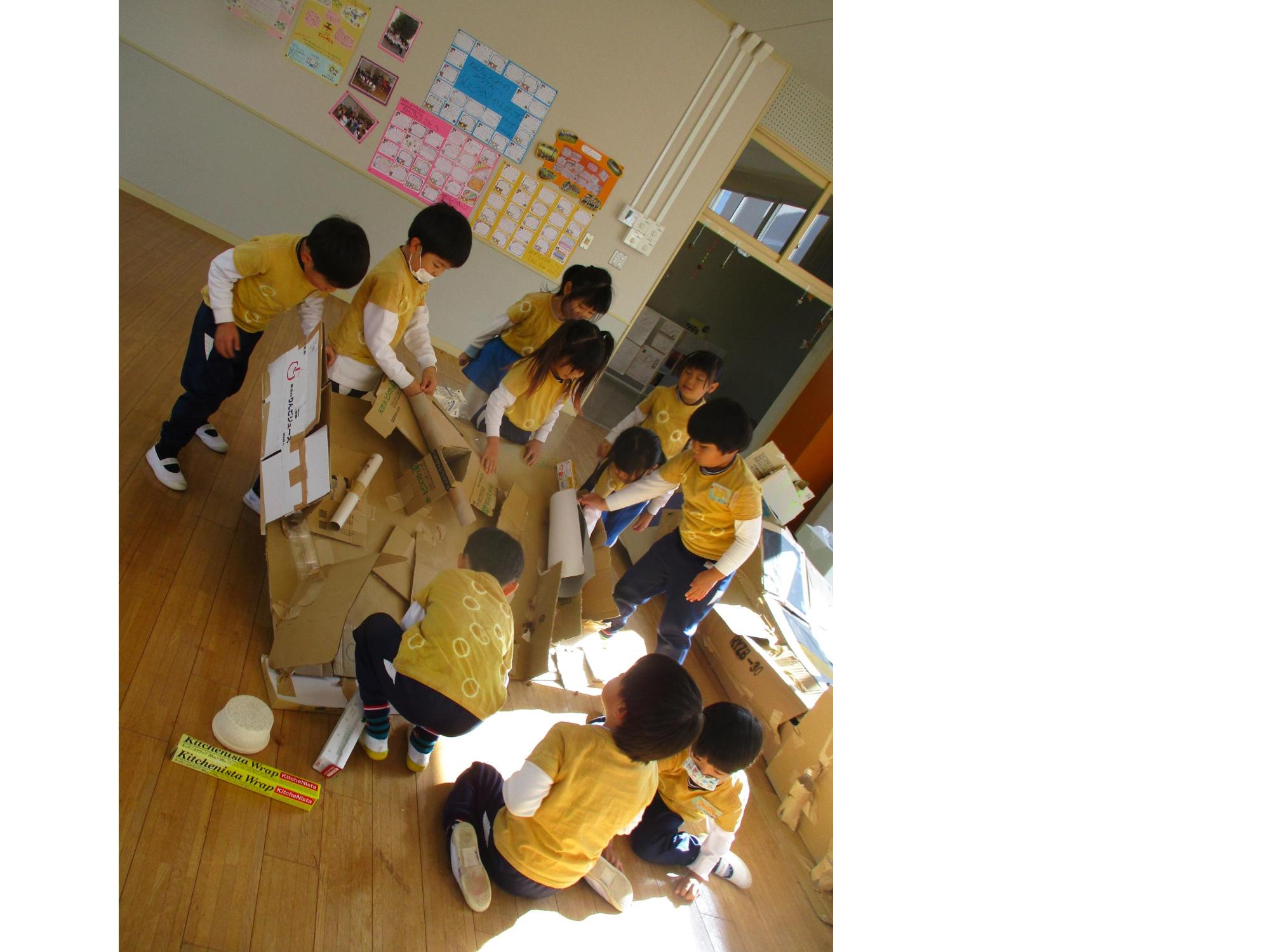 園児達が相談し、どんぐり転がしのコースを作っている写真