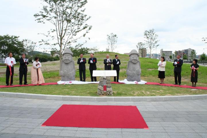 幕から姿を現した韓国済州道のシンボル・トルハルバン石像2体の写真