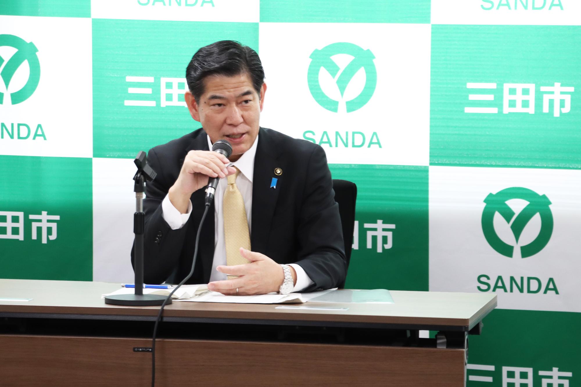 令和7年3月14日臨時記者会見で説明する田村市長の写真