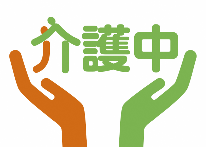オレンジ色と緑色の手が「介護中」の文字を包むようなデザインの介護マーク