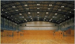 照明のついた大きな体育館の内部の写真