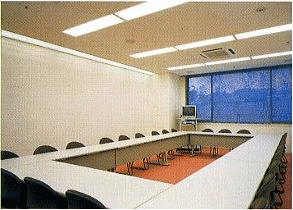 長机が長方形に並べられた会議室の写真