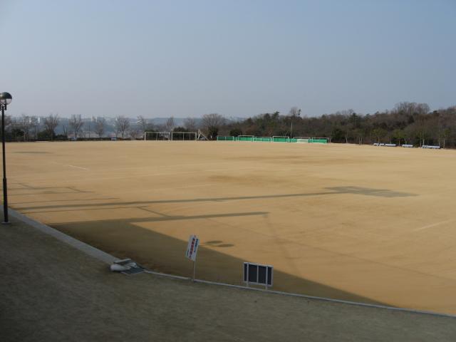 茶色の地面が広がっている陸上競技場の写真