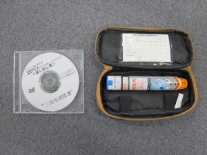 DVDが入った透明なケースと、太いペンのような形をした道具が入っている横長のケースの写真