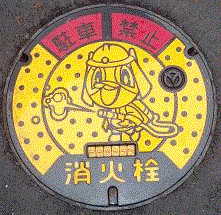消防士のキャラクターのイラストが描かれた、黄色をした消火栓の蓋の写真