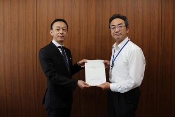 10月6日に佐藤委員長から笑顔で答申を受ける鹿嶽教育長の写真