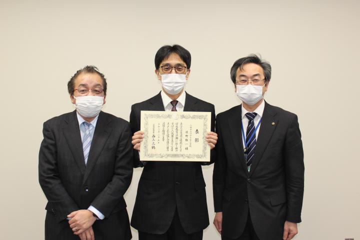 兵庫県優秀教職員の表彰状を持った佐野教諭と、福井校長、鹿嶽教育長の並んでいる写真