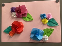 青や赤、紫などの様々な折り紙を用いて表現された花の折り紙作品の写真