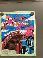 鮮やかな色合いで描かれている赤い橋と桜の作品の写真